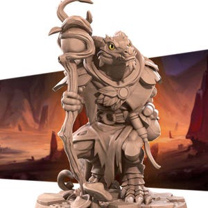 May include: A detailed miniature figurine of a lizard-like creature wearing a robe and holding a staff. The figurine is painted in shades of brown and has a yellow eye. The figurine is standing on a base with a rocky texture.