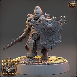 May include: A gray plastic miniature figurine of a dwarf warrior wearing armor and holding a sword and shield. The miniature is standing on a round base with a design of interlocking circles.