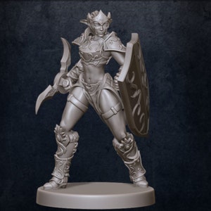 Puede incluir: Una figura en miniatura gris y detallada de una guerrera elfa. Lleva armadura y sostiene una espada y un escudo.