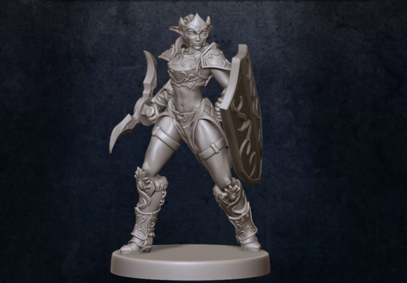 Puede incluir: Una figura en miniatura gris y detallada de una guerrera elfa. Lleva armadura y sostiene una espada y un escudo.