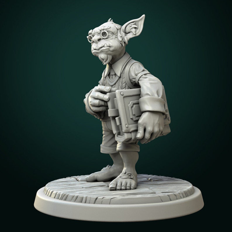 May include: A gray, sculpted figurine of a goblin wearing glasses and a vest, holding a closed book. The goblin is standing on a wooden base.