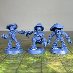 May include: Three blue miniature fantasy figures, each with a mushroom cap head and a gnarled, tree-like body. The figures are posed with outstretched arms and menacing expressions, suitable for tabletop gaming or display.