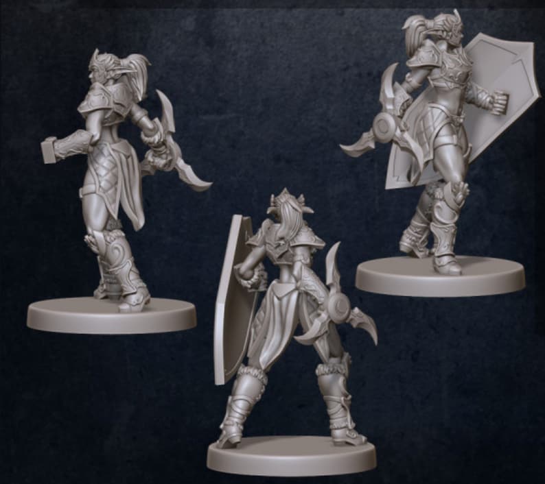 Puede incluir: Tres figuras en miniatura pintadas de gris de una guerrera con un escudo y una daga. Las figuras est&aacute;n en diferentes posturas, mostrando las vistas frontal, posterior y lateral de la figura.