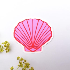 Könnte beinhalten: Ein pinkfarbener Muschelsticker mit roter Umrandung und Innenlinien. Der Aufkleber befindet sich auf weißem Hintergrund, mit gelben Blumen in der unteren linken Ecke.