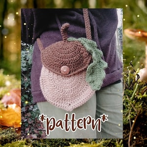 Peut inclure: Un sac en crochet en forme de gland avec un dessus brun et un dessous brun clair. Le sac a une feuille verte en crochet sur le côté et un bouton brun. Le sac est porté en bandoulière. *Modèle*