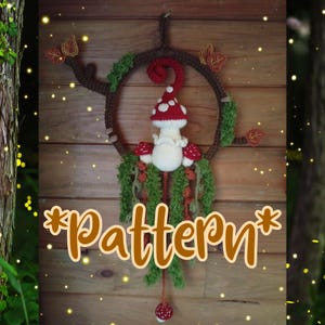 May include: A crocheted wall hanging featuring a brown circular branch frame adorned with green moss, orange leaves, and a central white mushroom figure with a red cap. The text *Pattern* is displayed in brown cursive font at the bottom center.