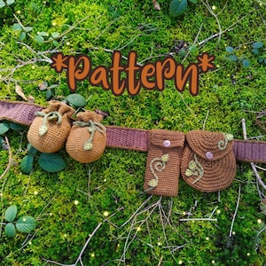 May include: Crocheted brown belt with two small pouches and a larger pouch with a flap. The pouches have green leaf details. The text "*Pattern*" is written in brown letters on a green mossy background.