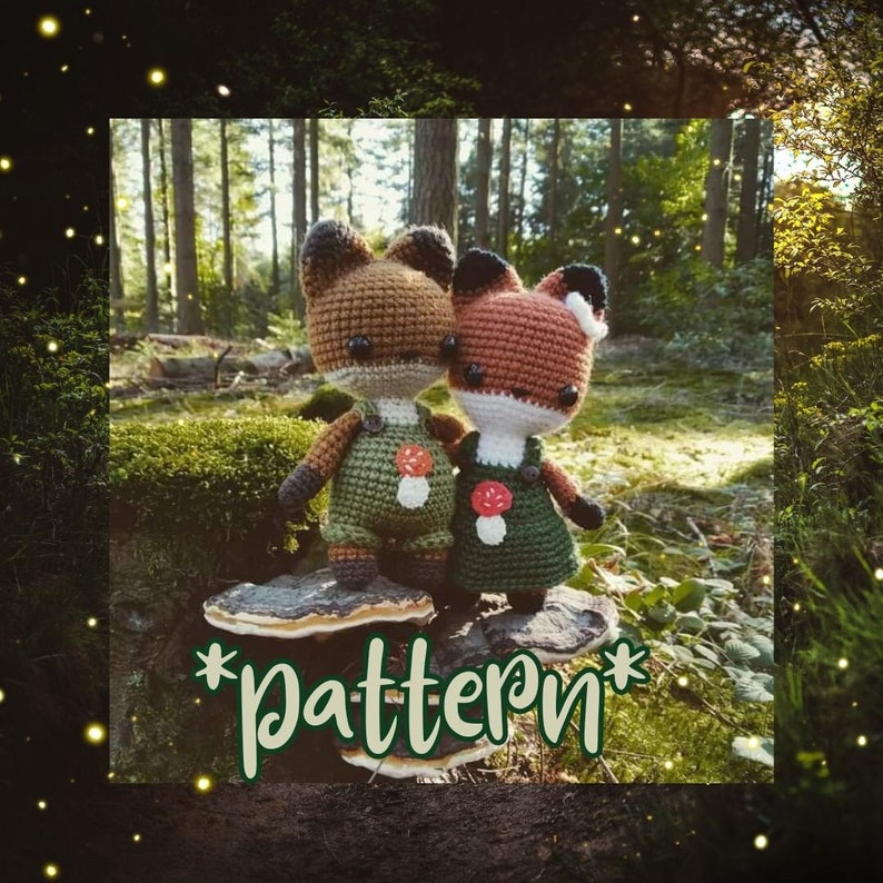 May include: Two crocheted fox plushies wearing green overalls with mushroom accents stand on a mushroom in a forest setting. The text "*pattern*" is written on the mushroom.