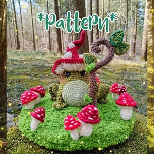 Może przedstawiać: Szydełkowa żaba w czerwono-białym kapeluszu w kształcie grzyba, otoczona czerwono-białymi figurkami grzybów, wszystko na zielonej szydełkowej podstawie. Słowo "Pattern" jest napisane zielonym skryptem nad żabą.