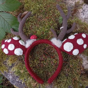May include: A handmade, red crocheted headband with attached brown antlers and red mushroom-shaped ear covers with white spots. The headband is decorated with white faux fur and a small red mushroom.
