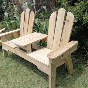 May include: A wooden bench with two seats and a small table in the middle. The bench is made of natural wood and has a rustic look. The bench is perfect for outdoor use.