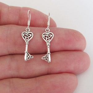 May include: Sterling silver Celtic knot key earrings with a heart-shaped keyhole and a trinity knot at the bottom.