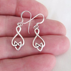 May include: A pair of silver dangle earrings with a Celtic knot design. The earrings are in the shape of an infinity symbol.