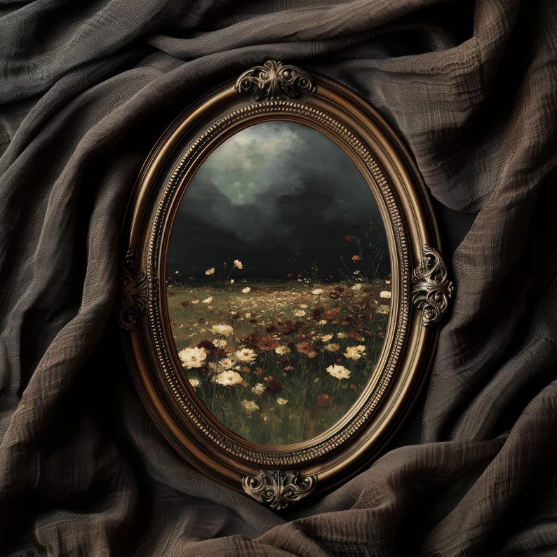 May include: An oval-shaped, antique gold-colored frame with ornate detailing surrounds a landscape painting. The painting depicts a field of wildflowers under a dark, cloudy sky. The frame is set against a backdrop of draped, dark gray fabric.