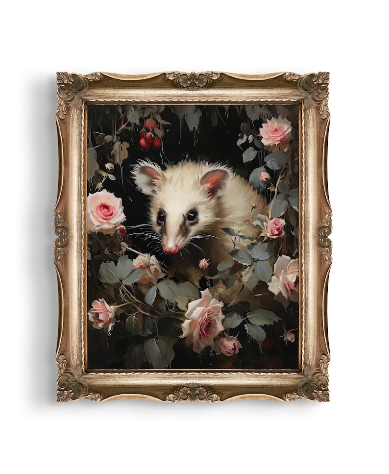 May include: A framed artwork featuring a white opossum amidst pink roses and foliage against a dark background. The painting is in a gold ornate frame, creating a vintage aesthetic. The opossum has a pink nose and dark eyes.
