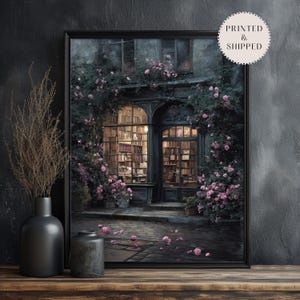 May include: A framed print of a romantic bookstore scene. The image features a building with arched windows and doors, surrounded by climbing roses. The interior is filled with bookshelves and soft lighting. The print is labeled "PRINTED & SHIPPED".