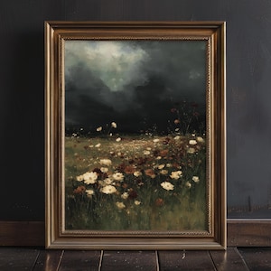 May include: A framed landscape painting featuring a field of wildflowers in shades of white and brown under a dark, cloudy sky. The artwork is set in a gold-colored frame, adding a touch of elegance to the natural scene.
