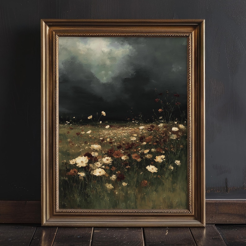 May include: A framed landscape painting featuring a field of wildflowers in shades of white and brown under a dark, cloudy sky. The artwork is set in a gold-colored frame, adding a touch of elegance to the natural scene.