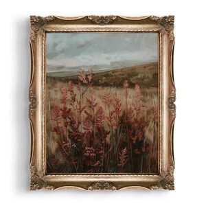 May include: An antique-style framed landscape painting. The artwork depicts a field of tall, reddish-brown plants under a cloudy sky. The ornate gold frame adds a vintage aesthetic to the artwork, suitable for home decor.