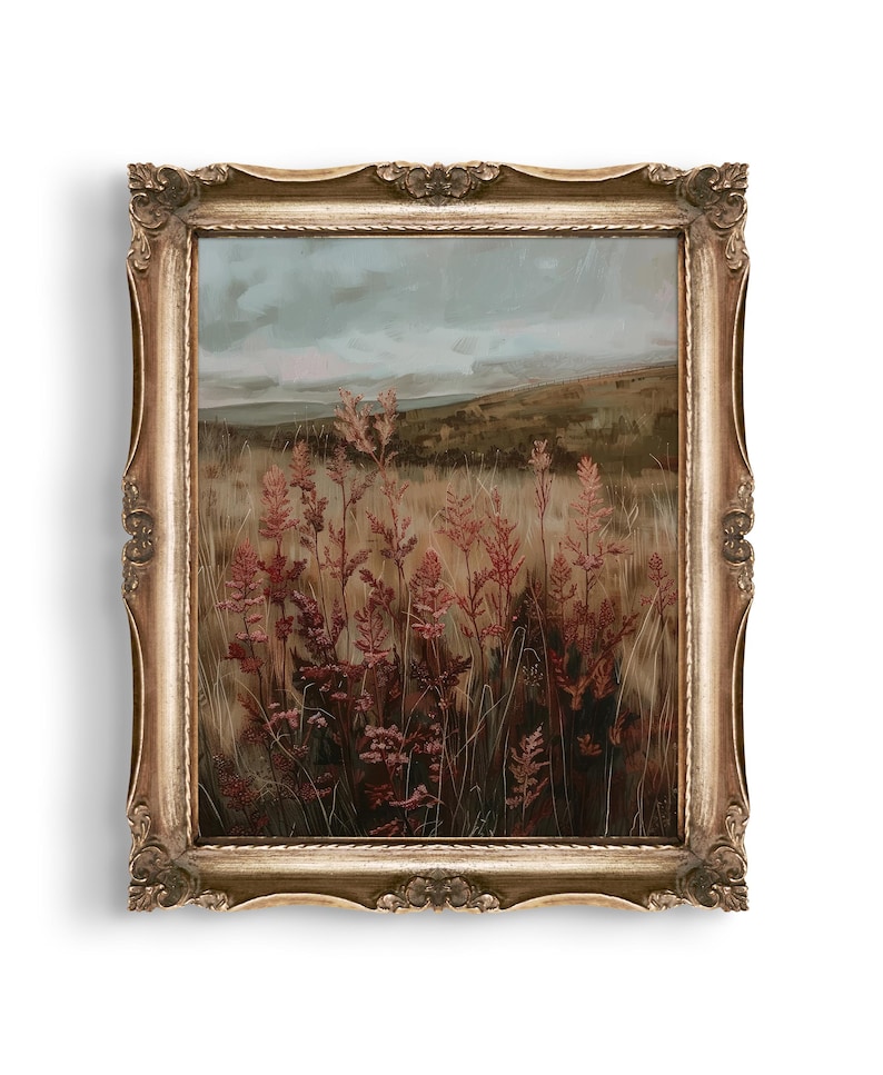 May include: An antique-style framed landscape painting. The artwork depicts a field of tall, reddish-brown plants under a cloudy sky. The ornate gold frame adds a vintage aesthetic to the artwork, suitable for home decor.
