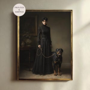 May include: A framed print of a vintage painting featuring a woman in a long black dress holding a leash attached to a Rottweiler dog. The painting has a gold frame and the text "PRINTED & SHIPPED" is in a circle in the upper left corner.