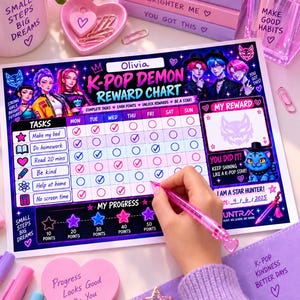 Puede incluir: Una tabla de recompensas K-Pop Demon con una cuadrícula de tareas semanal, seguimiento de progreso e ilustraciones de personajes. La tabla incluye textos como Olivia, K-Pop Demon Reward Chart y My Reward, junto a un bolígrafo rosa.