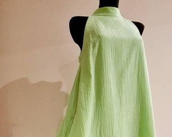 May include: A light green sleeveless dress with a high neckline and a ruffled hem.