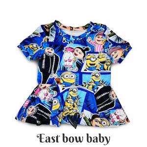 May include: Blue baby dress featuring a colorful print of characters from the animated movie "Despicable Me" and the Minions. The dress has short sleeves and a flared skirt. The text "East bow baby" is printed at the bottom.