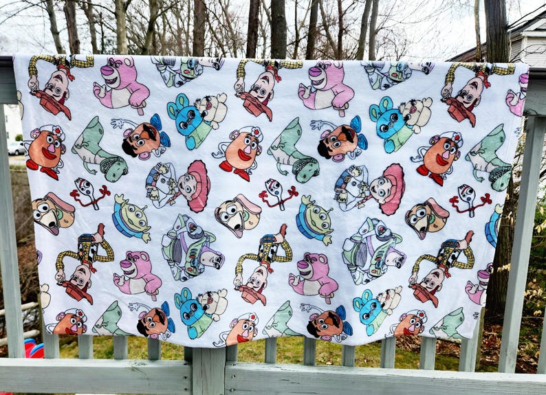 Może przedstawiać: Biała tkanina z powtarzającym się wzorem postaci z Toy Story. Postacie to Woody, Buzz Astral, Jessie, Pan i Pani Potato Head, Rex i Slinky Dog.