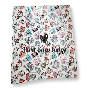 Może przedstawiać: Biały koc z polaru z powtarzającym się wzorem postaci z Toy Story. Koc ma napis "Last bow baby" czarnymi literami.