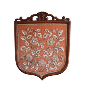 May include: A vintage wooden framed fire screen with an orange fabric panel embroidered with white and brown floral designs.
