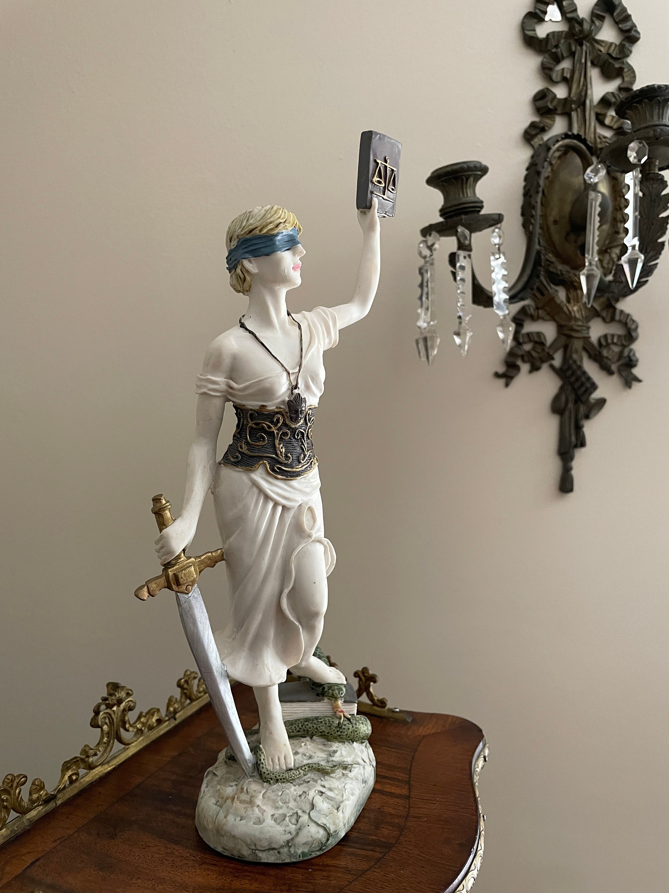 目隠しをした正義の女神の彫刻、天秤を持つ剣と本のシンボル