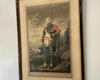 Pode incluir: Uma impressão emoldurada de um homem em uniforme militar, de pé em um cenário de paisagem. Ele está vestindo um kilt vermelho e verde, uma faixa branca e um chapéu preto. A impressão está em uma moldura preta e dourada.