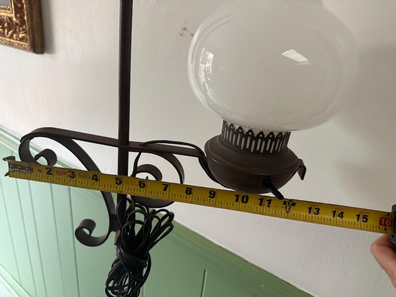 May include: A vintage hanging lamp with a white globe shade and a dark brown metal frame. The lamp's total length is approximately 16 inches. The lamp has a decorative metal base and a black electrical cord.