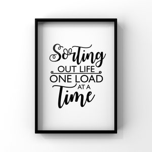 Op de afbeelding: Zwart-witte printbare wandkunst met de tekst "Het leven sorteren, één lading tegelijk".