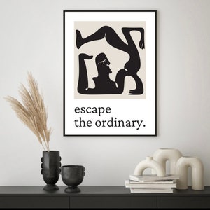 May include: Black and white minimalist art print featuring two figures in a yoga pose. The print has a beige background and the text "escape the ordinary."