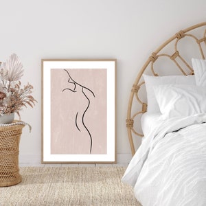 May include: A framed print of a line drawing of a person's body on a pink background.