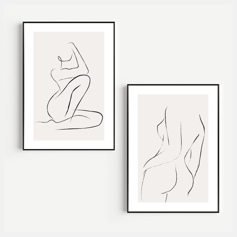 Pu&ograve; includere: Due stampe minimaliste di arte di linea di una figura nuda in posizione seduta e in piedi. Le stampe sono incorniciate in nero e hanno uno sfondo beige.