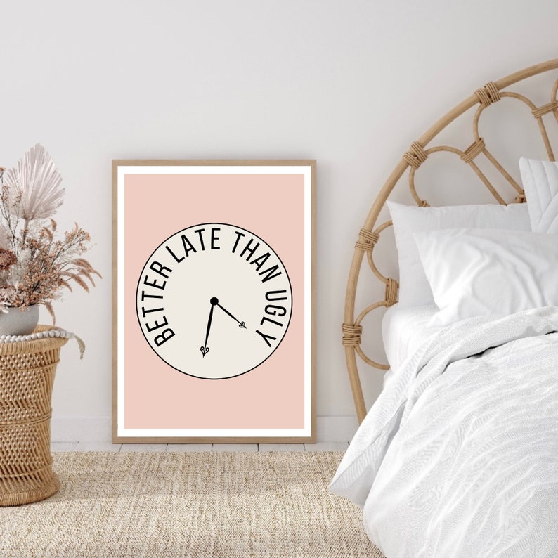 May include: A pink and white printable wall art print with a clock face that says "Better Late Than Ugly".
