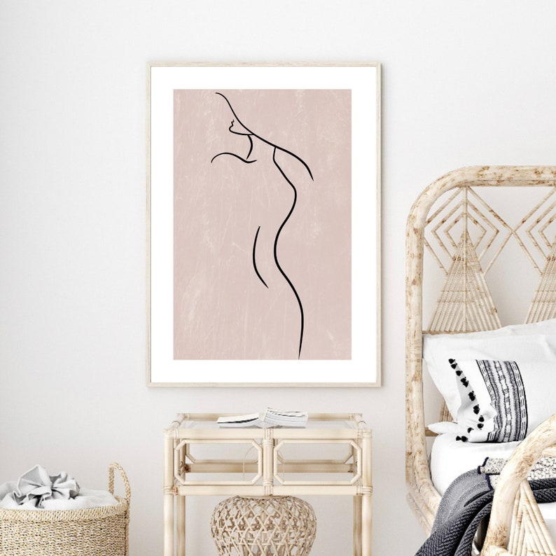 May include: A minimalist line drawing of a person's body in black on a light pink background. The drawing is framed in a simple wooden frame.