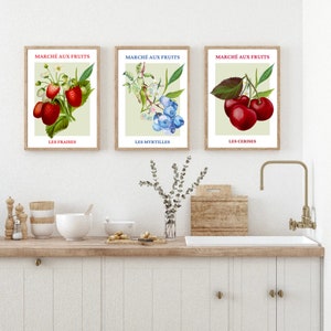 May include: Three vintage-style prints with illustrations of strawberries, blueberries, and cherries. Each print has the French text "March&eacute; aux fruits" at the top and the name of the fruit in French at the bottom.