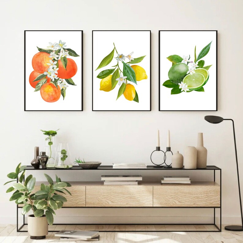 May include: Three framed watercolor paintings of citrus fruits with white blossoms. The first painting shows oranges, the second shows lemons, and the third shows limes.