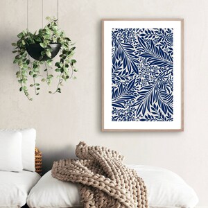 May include: A framed print with a navy blue floral pattern on a white background. The print features a repeating design of leaves and flowers.