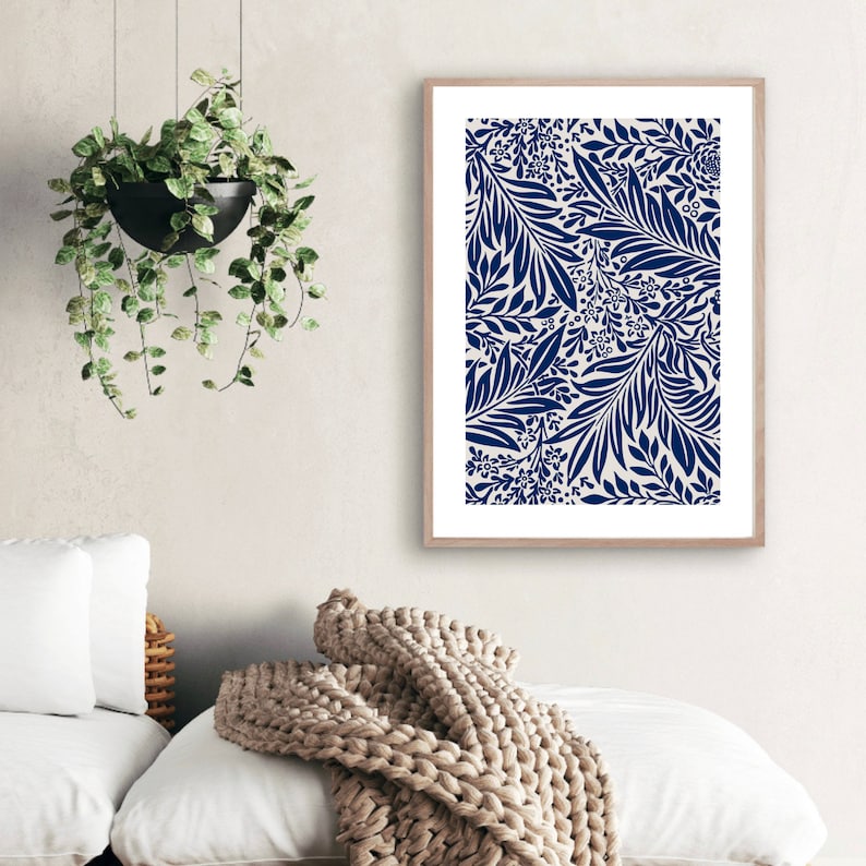 May include: A framed print with a navy blue floral pattern on a white background. The print features a repeating design of leaves and flowers.
