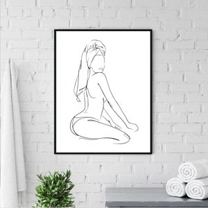 K&ouml;nnte beinhalten: Linienkunst-Druck einer Person, die mit einem Handtuch um den Kopf sitzt. Der Druck ist in Schwarzwei&szlig; und in einem schwarzen Rahmen gerahmt.
