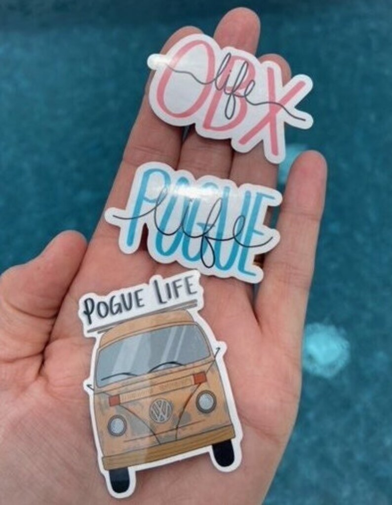 May include: Three stickers featuring the text "OBX life", "Pogue Life" and a vintage Volkswagen van with the text "Pogue Life" on the roof.
