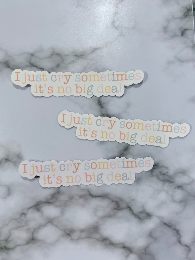 Op de afbeelding: Drie stickers met de tekst "I just cry sometimes it's no big deal" in verschillende pastelkleuren op een marmeren achtergrond.