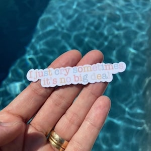 May include: A sticker with the text "I just cry sometimes it's no big deal" in rainbow colors on a white background.