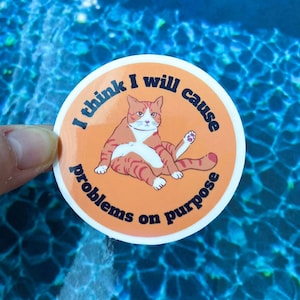 May include: Orange and white cat sticker with the text "I think I will cause problems on purpose".