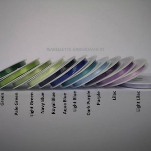 May include: A collection of spools of ribbon in various colors, including emerald green, green, pale green, light green, navy blue, royal blue, aqua blue, light blue, dark purple, purple, lilac, and light lilac. The spools are arranged in a row, with the darkest colors on the left and the lightest colors on the right. The text "ISABELLETTE HABERDASHERY" is visible at the top of the image.